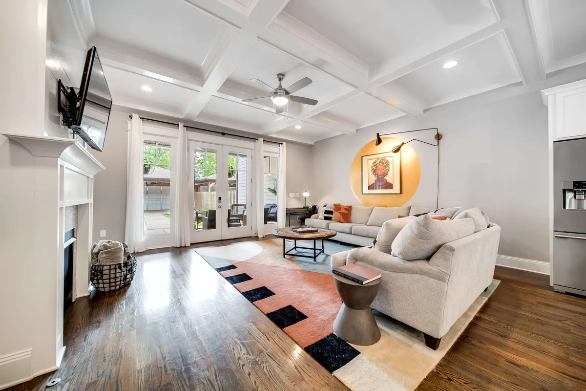 An inviting living space with a comfortable sofa, expressive artwork, a cozy fireplace, and patio doors that hint at seamless access to outdoor entertaining. The room exudes warmth and is perfect for hosting private after-parties or enjoying a quiet evening after exploring the city.