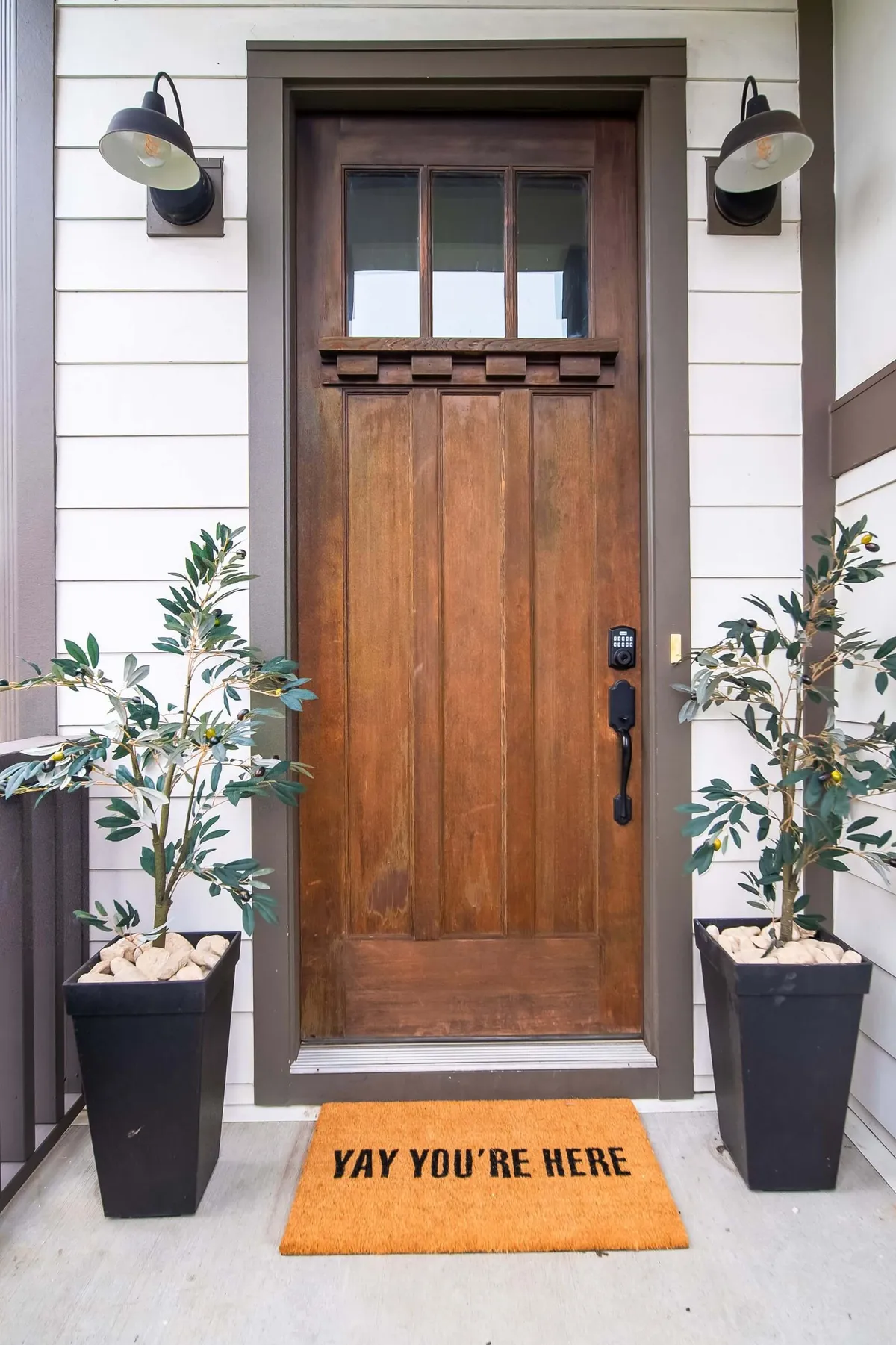 This image features a welcoming front door with a cozy welcome mat and surrounding greenery, setting a warm tone for arrivals and departures. The inviting entry emphasizes the home’s approachable and friendly atmosphere.